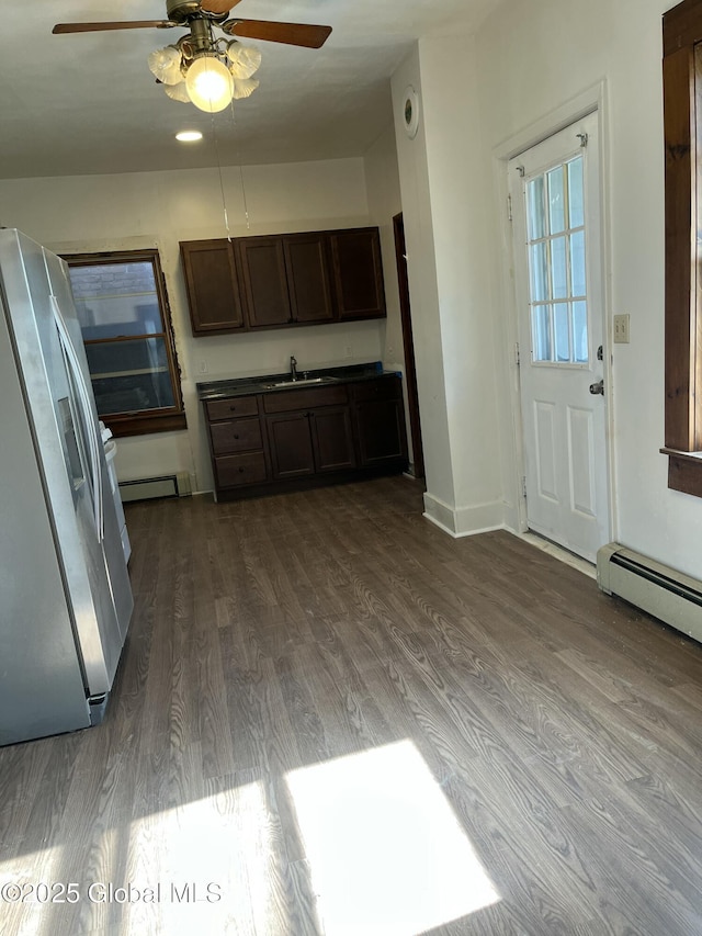 kitchen featuring freestanding refrigerator, ceiling fan, a baseboard heating unit, and dark wood finished floors
