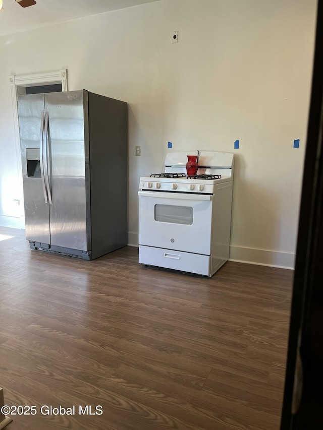 kitchen featuring stainless steel fridge, baseboards, dark wood-style flooring, and white range with gas cooktop