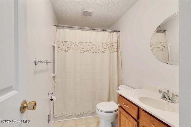 bathroom featuring visible vents, vanity, toilet, a shower with shower curtain, and a textured ceiling