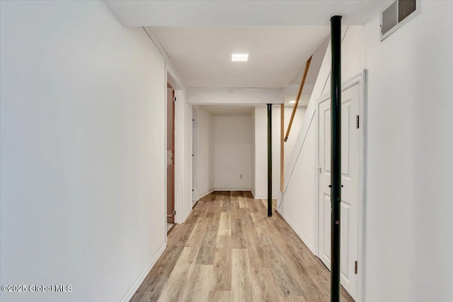 corridor with visible vents, baseboards, and light wood-type flooring