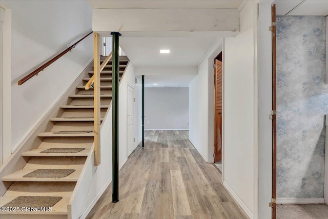 staircase with baseboards and wood finished floors