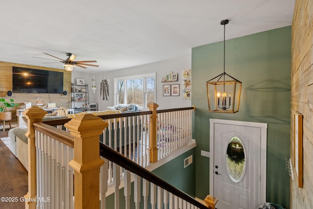 interior space with a baseboard radiator, visible vents, and ceiling fan with notable chandelier