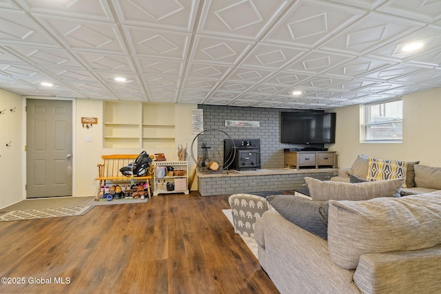 living area with recessed lighting, a wood stove, an ornate ceiling, and wood finished floors