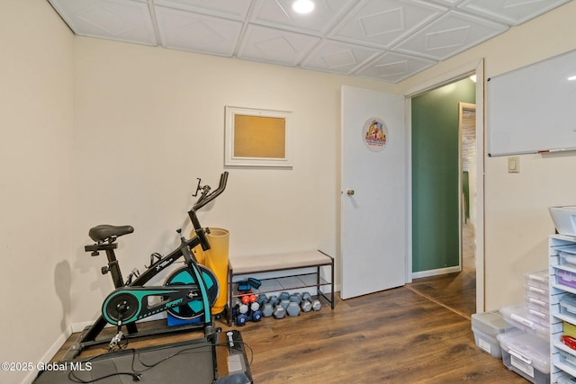 exercise area featuring baseboards and dark wood finished floors