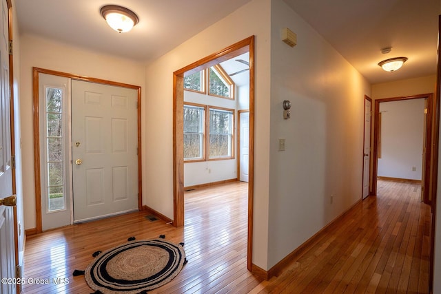 foyer entrance with baseboards, visible vents, and light wood-style flooring
