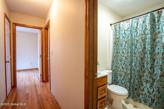 full bathroom with wood-type flooring, toilet, vanity, and a shower with shower curtain