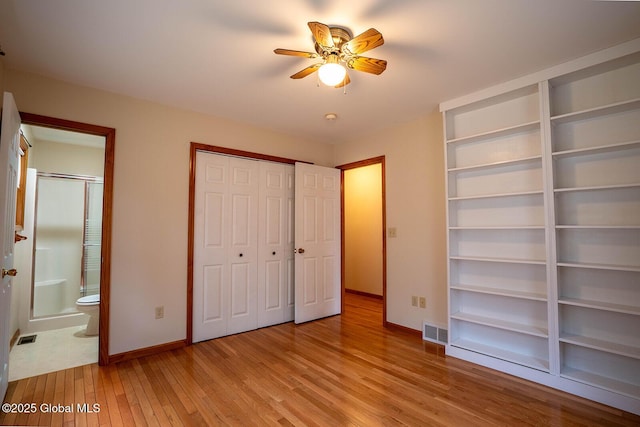 unfurnished bedroom with connected bathroom, baseboards, visible vents, and light wood-style flooring