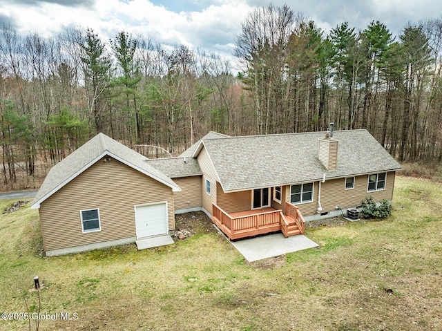 rear view of property featuring cooling unit, a lawn, a shingled roof, and a chimney