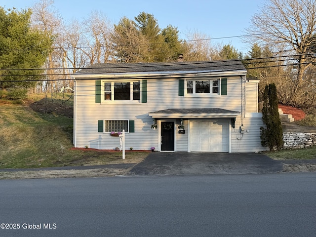 traditional home with an attached garage and aphalt driveway
