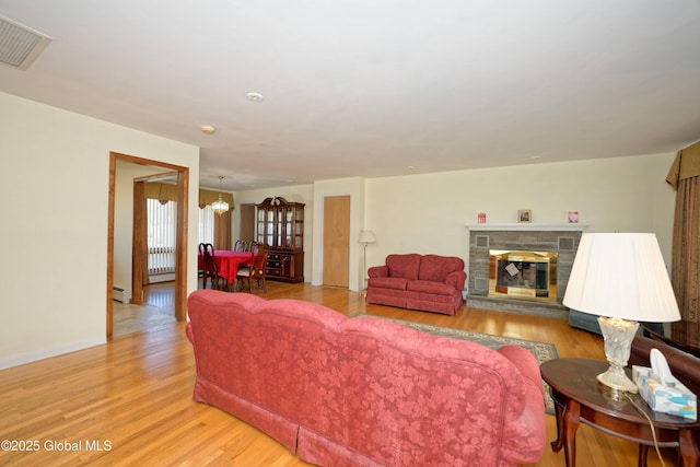 31 Tryon Ct, Albany, NY 12203 - living area with an inviting chandelier, visible vents, a baseboard heating unit, light wood-style floors, and a fireplace