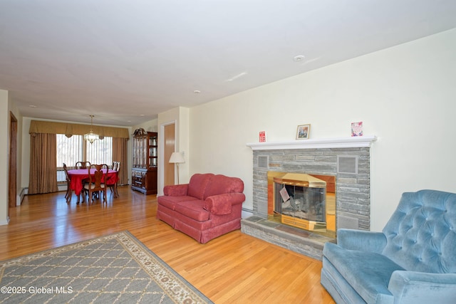 31 Tryon Ct, Albany, NY 12203 - living area with a chandelier, a baseboard radiator, wood finished floors, and a fireplace