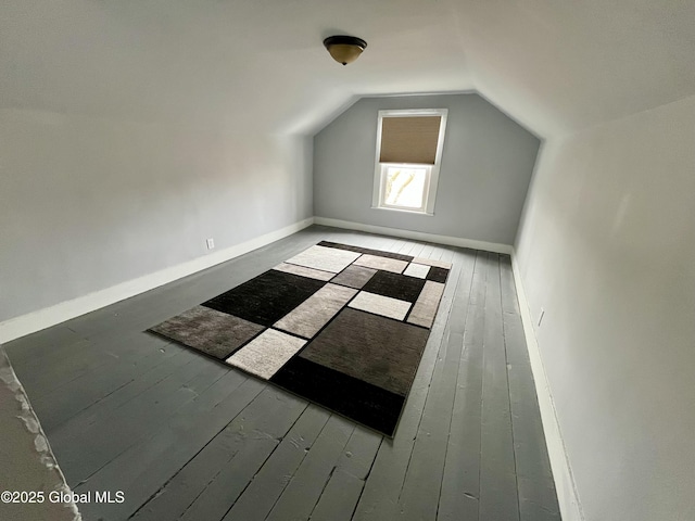 additional living space featuring baseboards, hardwood / wood-style floors, and lofted ceiling