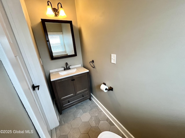 bathroom with baseboards, tile patterned flooring, and vanity