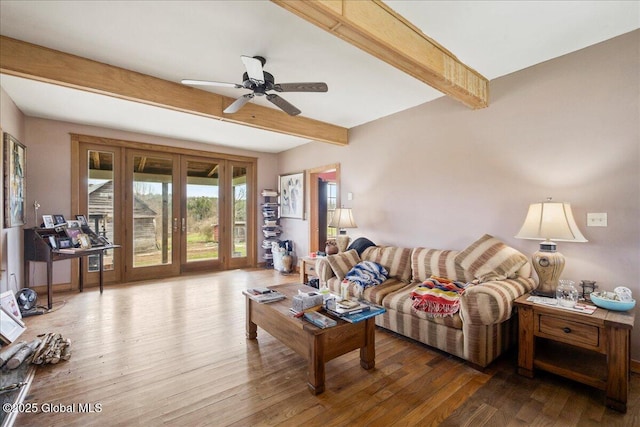 living room with ceiling fan, wood finished floors, and beam ceiling