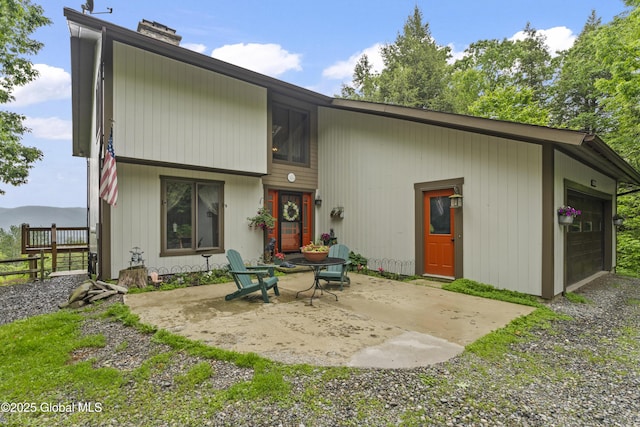 66 Schaeffer Rd, Berlin, NY 12138 - rear view of house with a chimney, a patio area, and an attached garage