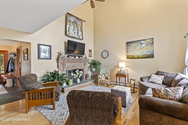 66 Schaeffer Rd, Berlin, NY 12138 - living area with a high ceiling, a baseboard heating unit, a fireplace, wood finished floors, and a ceiling fan