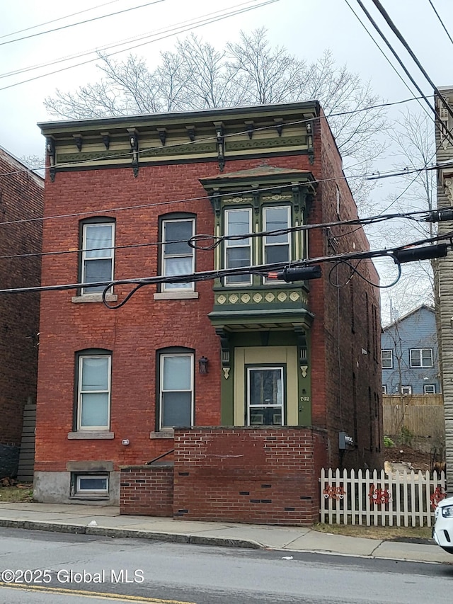 view of front of house with a fenced front yard and brick siding