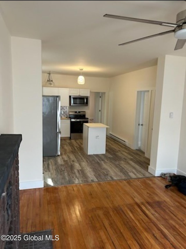 kitchen with white cabinetry, a kitchen island, dark wood finished floors, stainless steel appliances, and ceiling fan