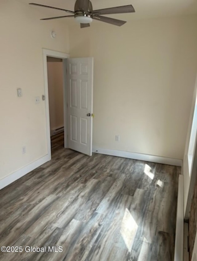 empty room featuring ceiling fan, baseboards, and wood finished floors