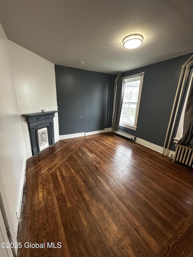 44 Storrie St, Amsterdam, NY 12010 - unfurnished living room featuring wood-type flooring, baseboards, and a fireplace