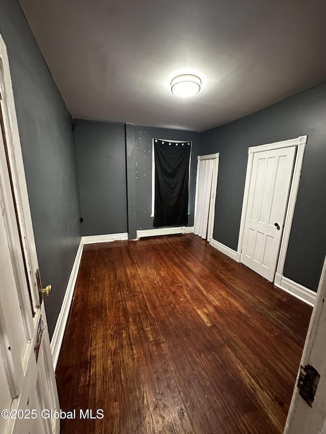 44 Storrie St, Amsterdam, NY 12010 - unfurnished bedroom featuring hardwood / wood-style floors, baseboards, and multiple closets