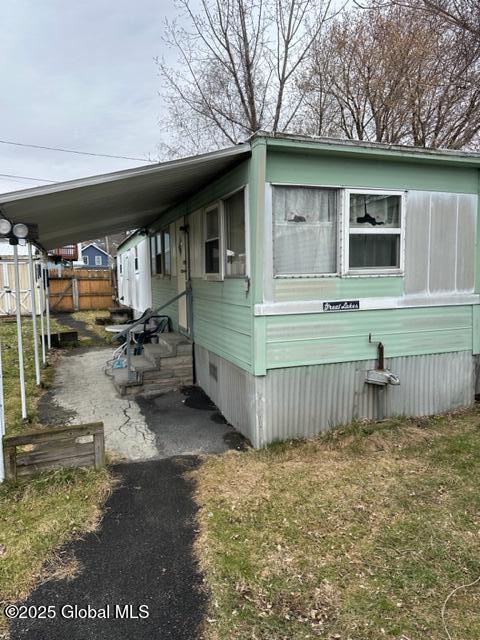 view of property exterior with fence and entry steps