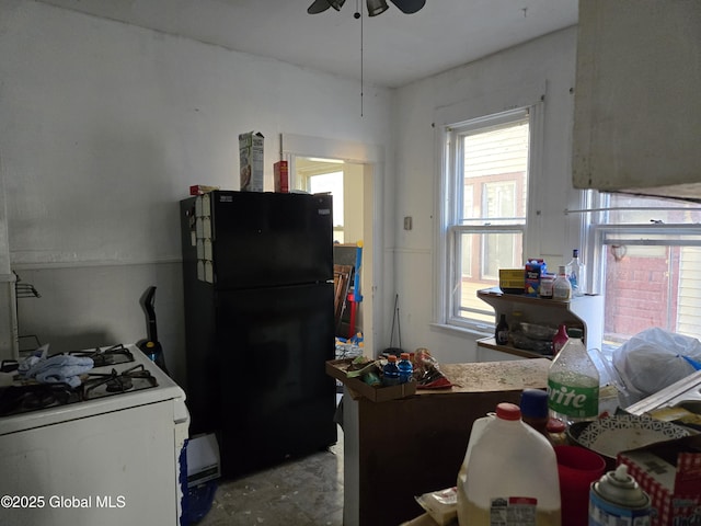 15 Kenyon Ct, Utica, NY 13501 - kitchen featuring freestanding refrigerator, white range with gas cooktop, a ceiling fan, and unfinished concrete floors