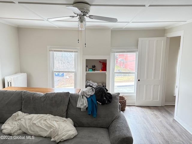 living room with radiator, wood finished floors, a ceiling fan, and plenty of natural light