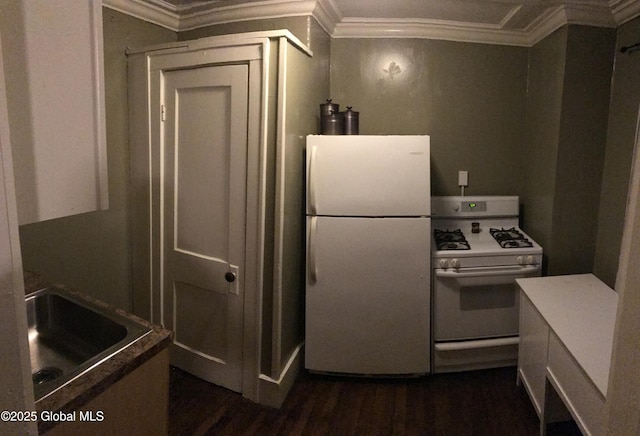 kitchen with a sink, ornamental molding, white appliances, and dark wood finished floors