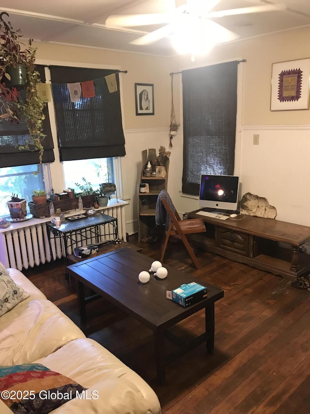 living room featuring wood finished floors, ceiling fan, and wainscoting