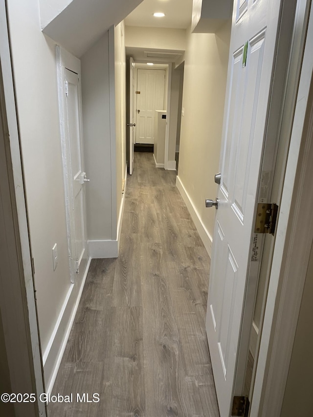 hall featuring baseboards and wood finished floors