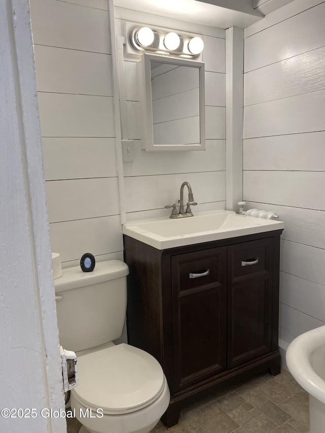 half bathroom featuring vanity and toilet
