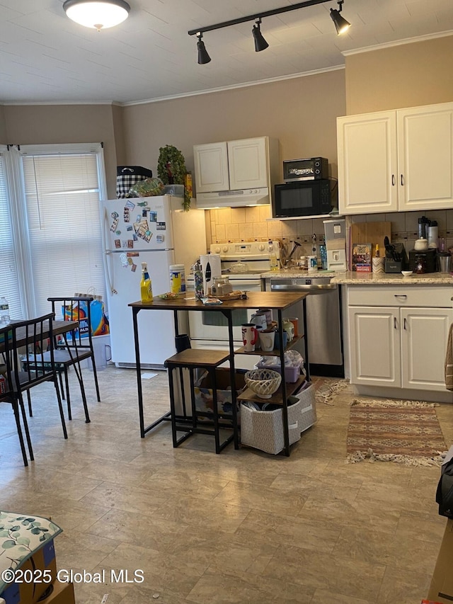 kitchen with white cabinets, decorative backsplash, white appliances, under cabinet range hood, and rail lighting