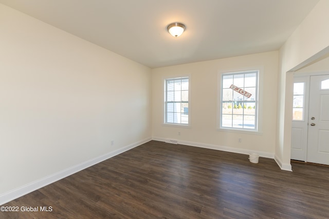 entrance foyer with plenty of natural light, dark wood-style floors, baseboards, and visible vents