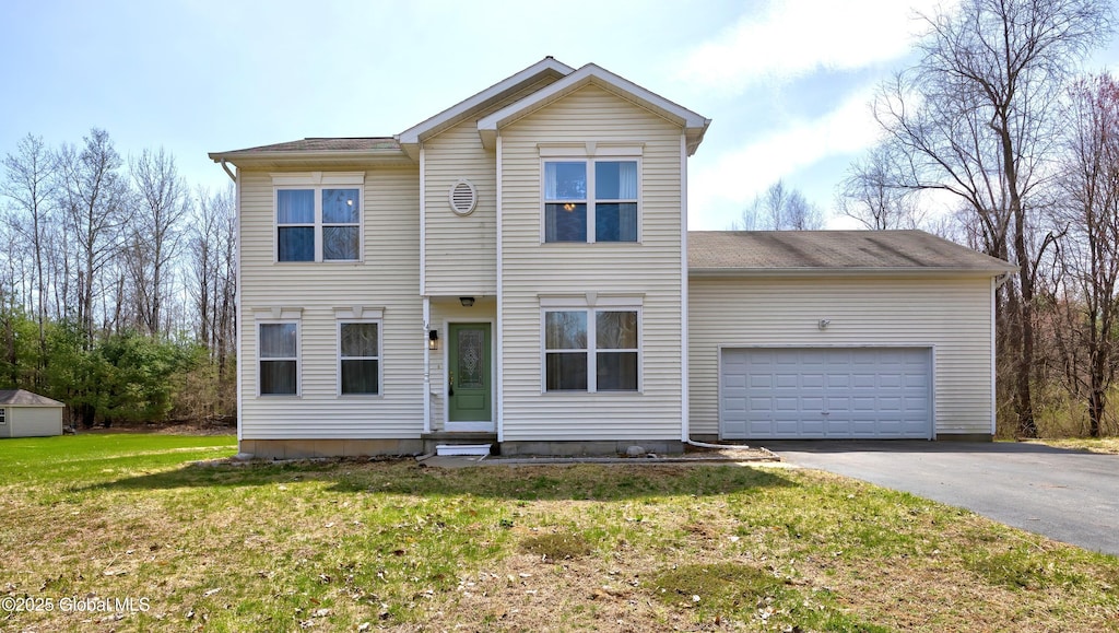 traditional home with an attached garage, driveway, entry steps, and a front yard