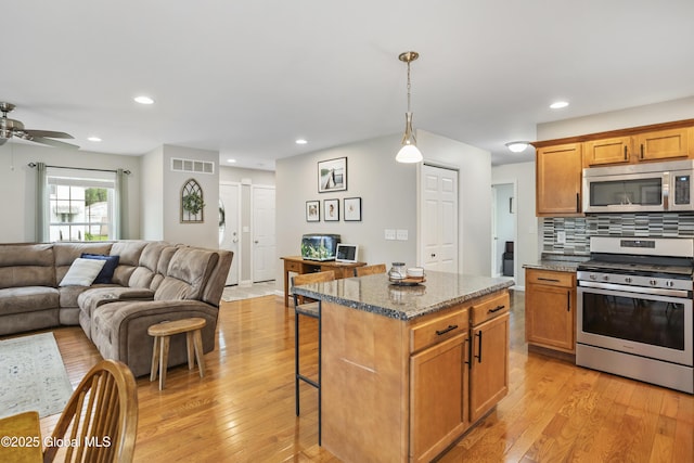 9 Barton Ave, Fort Edward, NY 12828 - kitchen with appliances with stainless steel finishes, open floor plan, a breakfast bar area, light wood-style floors, and a center island