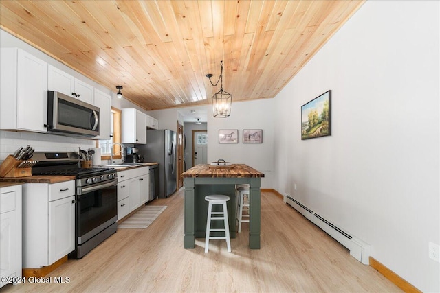 kitchen featuring butcher block countertops, a baseboard heating unit, light wood-style floors, stainless steel appliances, and wood ceiling