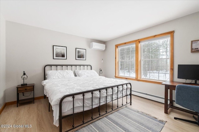 bedroom featuring an AC wall unit, a baseboard radiator, light wood finished floors, and baseboards