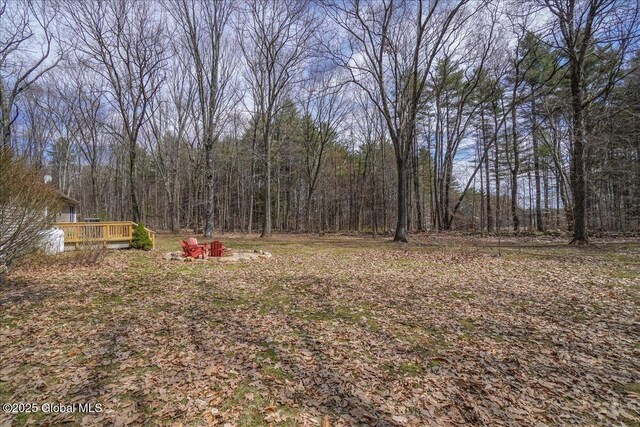 view of yard featuring a view of trees and a wooden deck