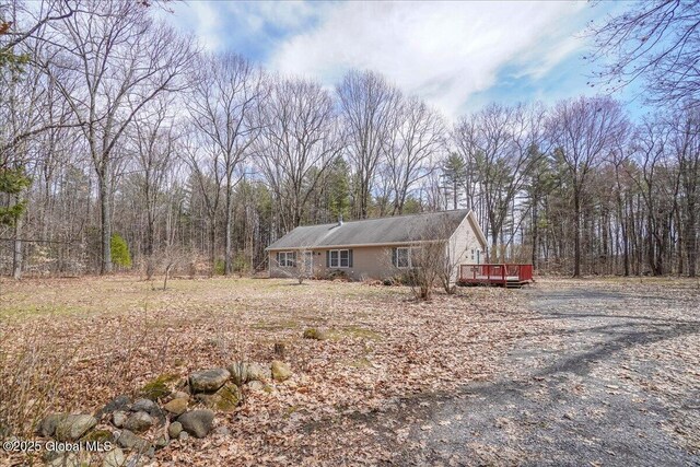 exterior space with a wooded view and a wooden deck