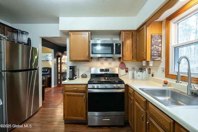 kitchen with a healthy amount of sunlight, light countertops, a sink, and appliances with stainless steel finishes