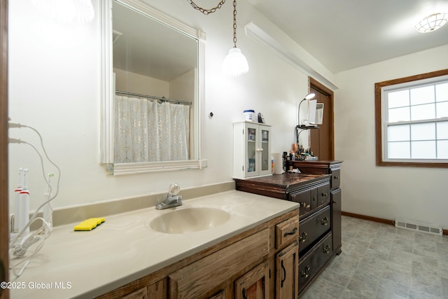bathroom with visible vents, baseboards, curtained shower, and vanity