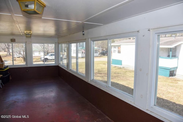 unfurnished sunroom featuring concrete flooring
