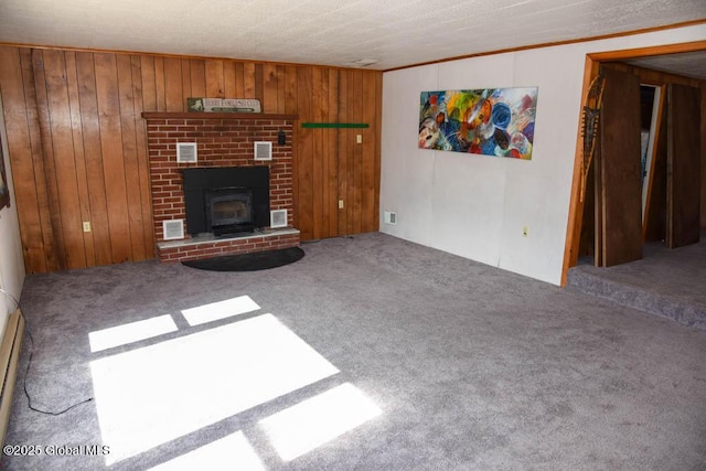 unfurnished living room with wooden walls, visible vents, and carpet floors