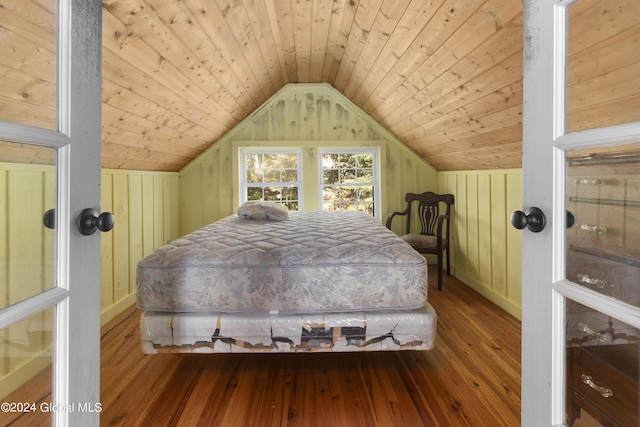 bedroom with wooden walls, lofted ceiling, hardwood / wood-style flooring, and wood ceiling