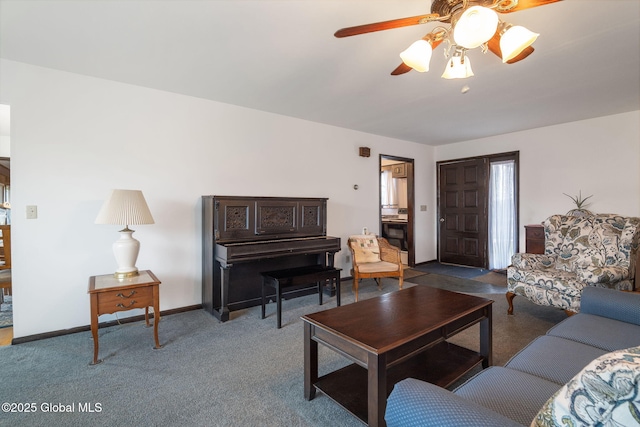 carpeted living area with baseboards and a ceiling fan
