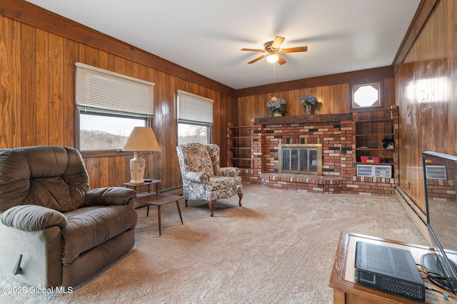 carpeted living room with wooden walls, a fireplace, a ceiling fan, and baseboard heating