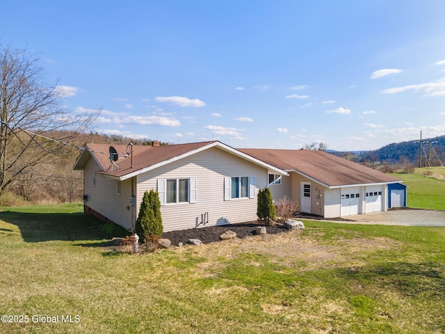 ranch-style home featuring an attached garage, driveway, and a front yard
