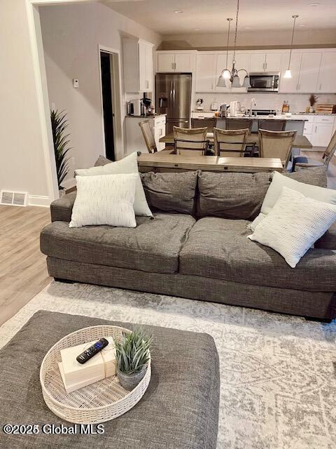 living area with visible vents and light wood-style flooring