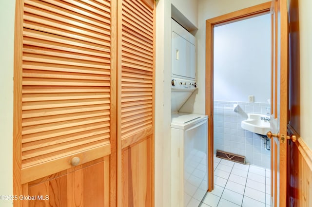 132 County Highway 152 Unit C, Northville, NY 12134 - washroom featuring estacked washer and dryer, light tile patterned flooring, tile walls, and a wainscoted wall